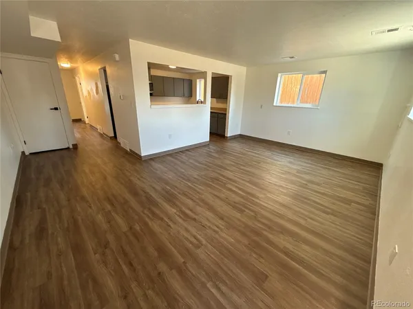 an empty room with wooden floor and a window