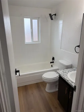 a bathroom with a granite countertop toilet a sink and bathtub