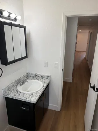 a bathroom with a granite countertop sink and a mirror