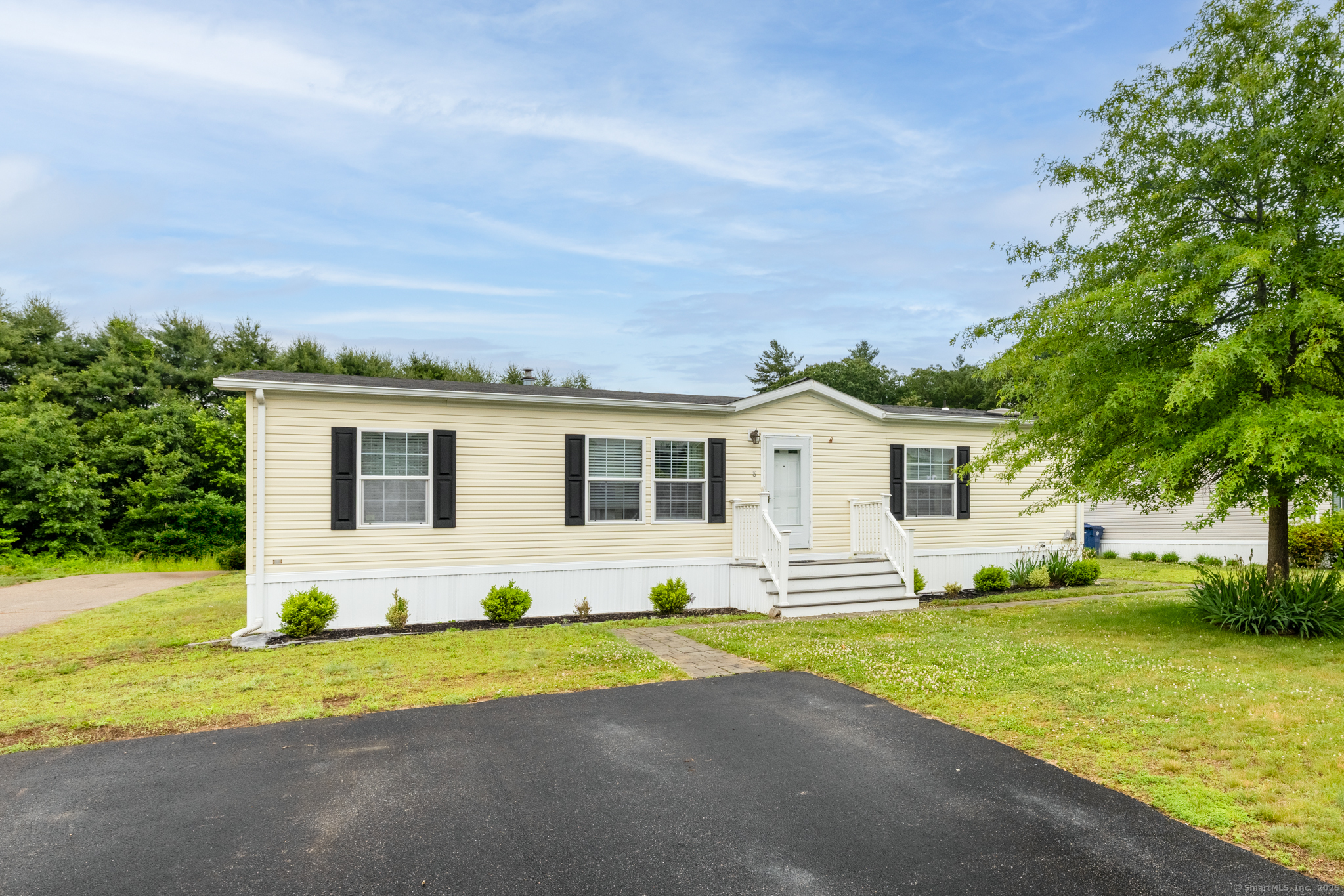 a front view of a house with a garden and yard