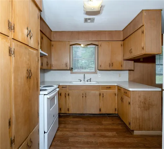 a view of a kitchen with wooden floor and a refrigerator