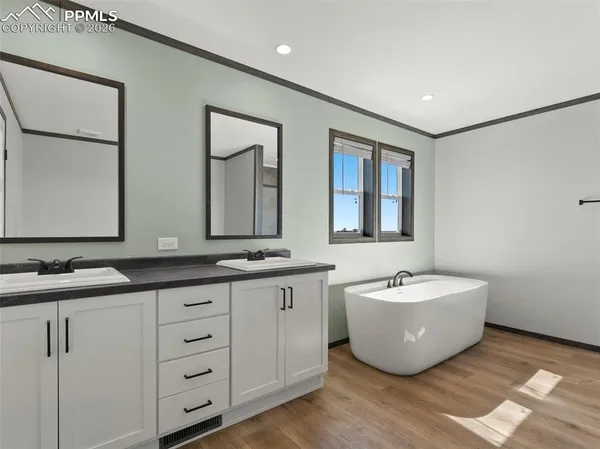 a bedroom with a bed and a large mirror next to a window