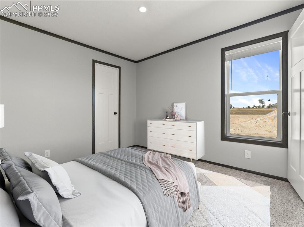 2820 East Ellicott Road South Calhan, CO 80808 - Photo 30 of 39 a bedroom with a bed and a large mirror next to a window