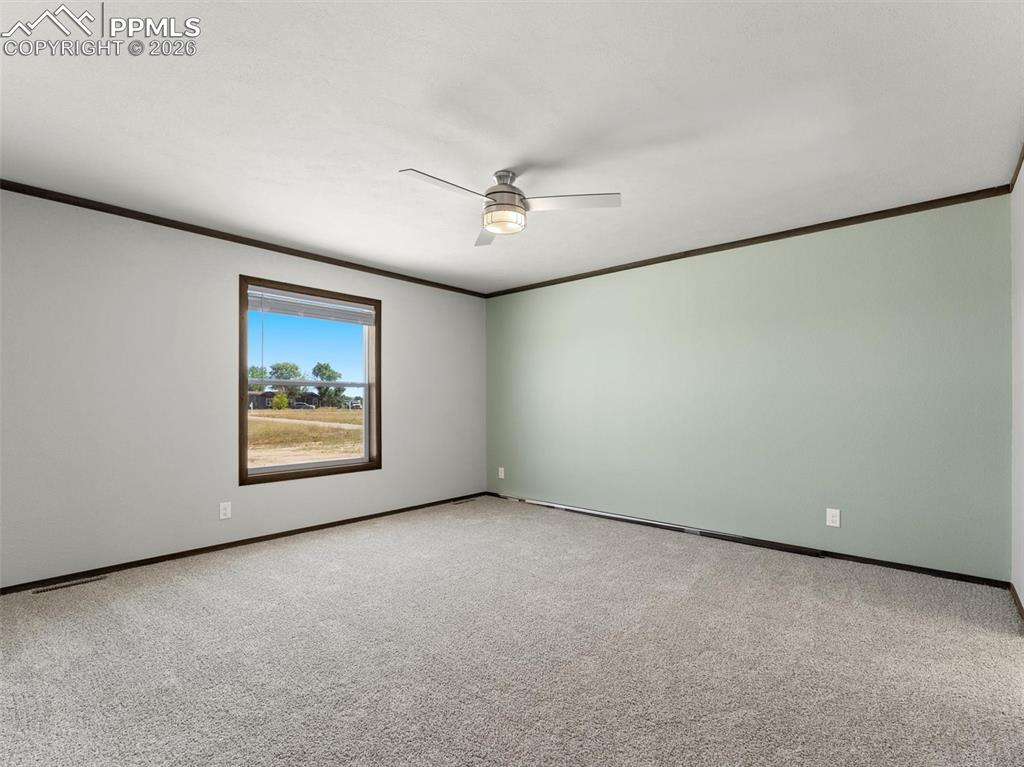 2820 East Ellicott Road South Calhan, CO 80808 - Photo 7 of 39 an empty room with a ceiling fan and a window