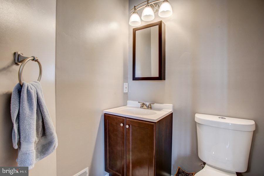 5036 Finsbury Road Baltimore, MD 21237 - Photo 7 of 34 a bathroom with a toilet sink and mirror