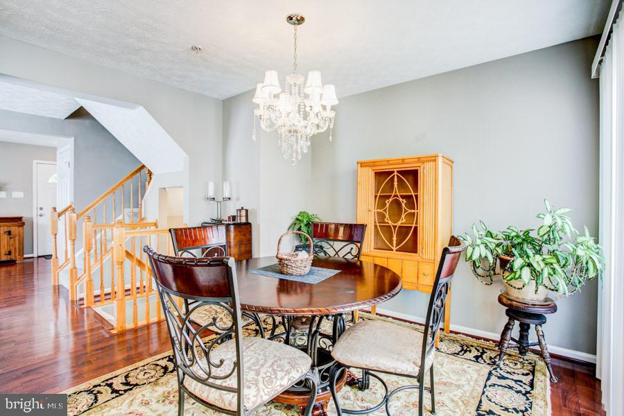 5036 Finsbury Road Baltimore, MD 21237 - Photo 9 of 34 a view of a dining room with furniture wooden floor and a chandelier