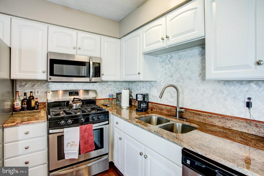 5036 Finsbury Road Baltimore, MD 21237 - Photo 10 of 34 a kitchen with granite countertop white cabinets stainless steel appliances and a sink