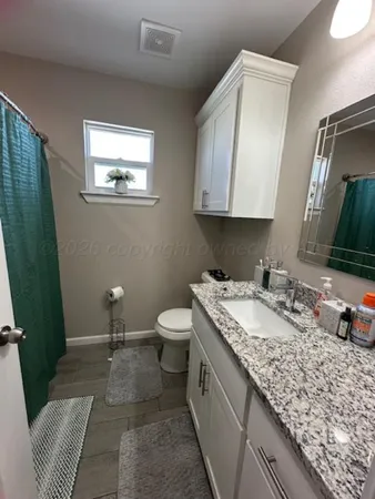 a bathroom with a granite countertop sink and a mirror