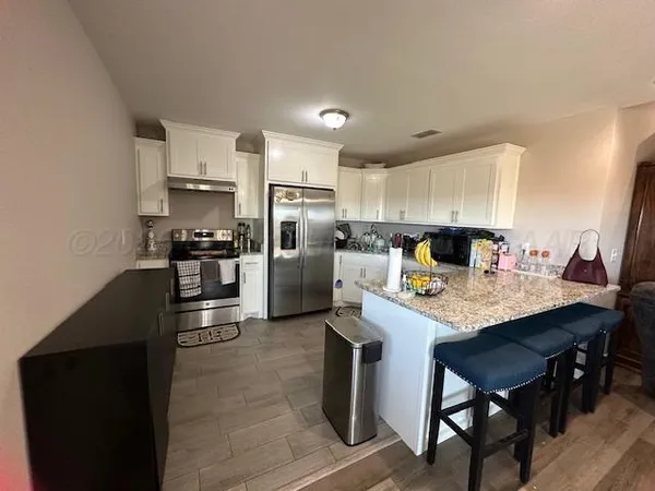 a kitchen with refrigerator cabinets and wooden floor