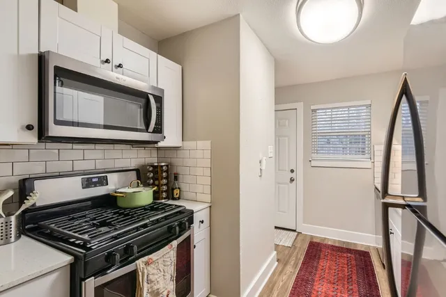 a kitchen with granite countertop a stove and a microwave