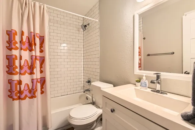 a bathroom with a granite countertop sink toilet and shower