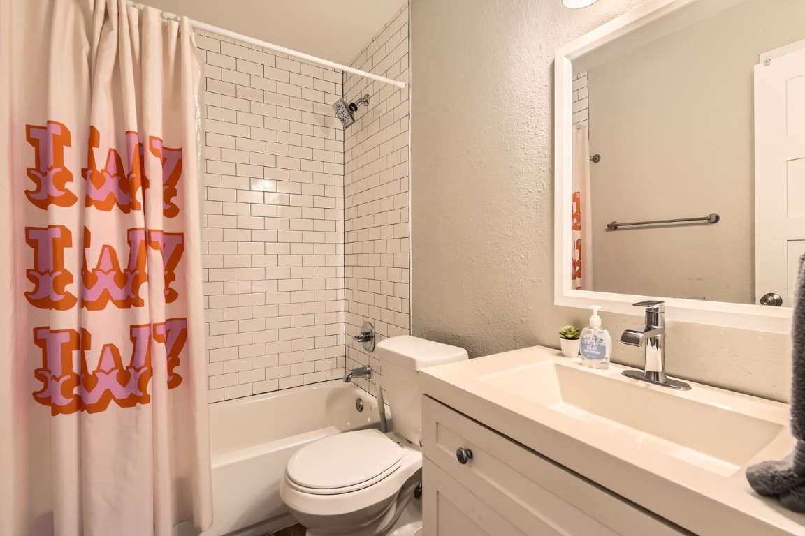 6108 Calmar Cove, Unit B Austin, TX 78721 - Photo 16 of 21 a bathroom with a granite countertop sink toilet and shower
