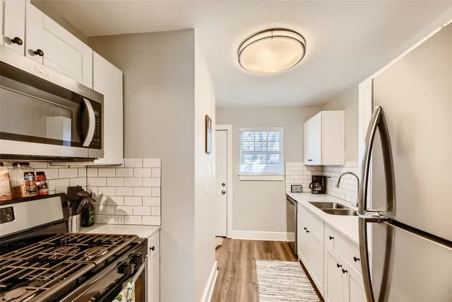 a kitchen with stainless steel appliances a stove microwave and sink