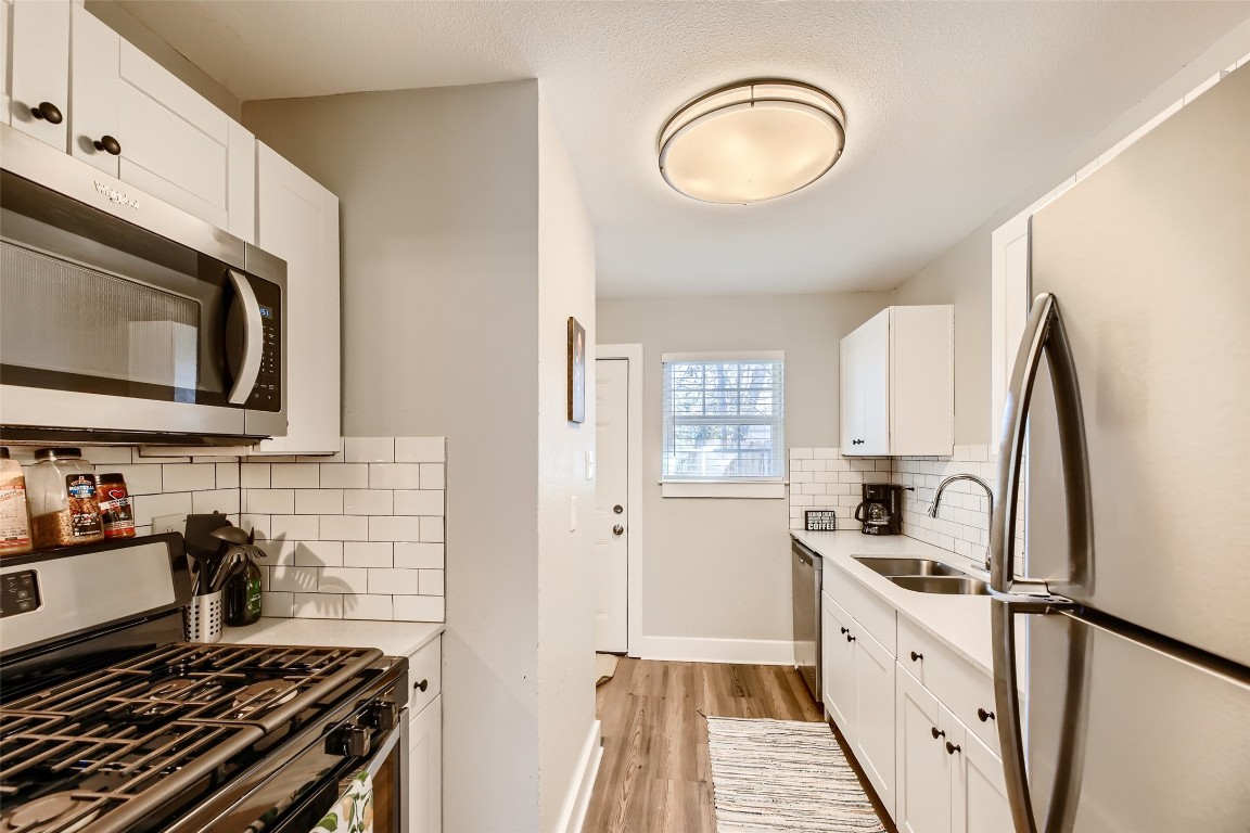 6108 Calmar Cove, Unit B Austin, TX 78721 - Photo 4 of 21 a kitchen with stainless steel appliances a stove microwave and sink
