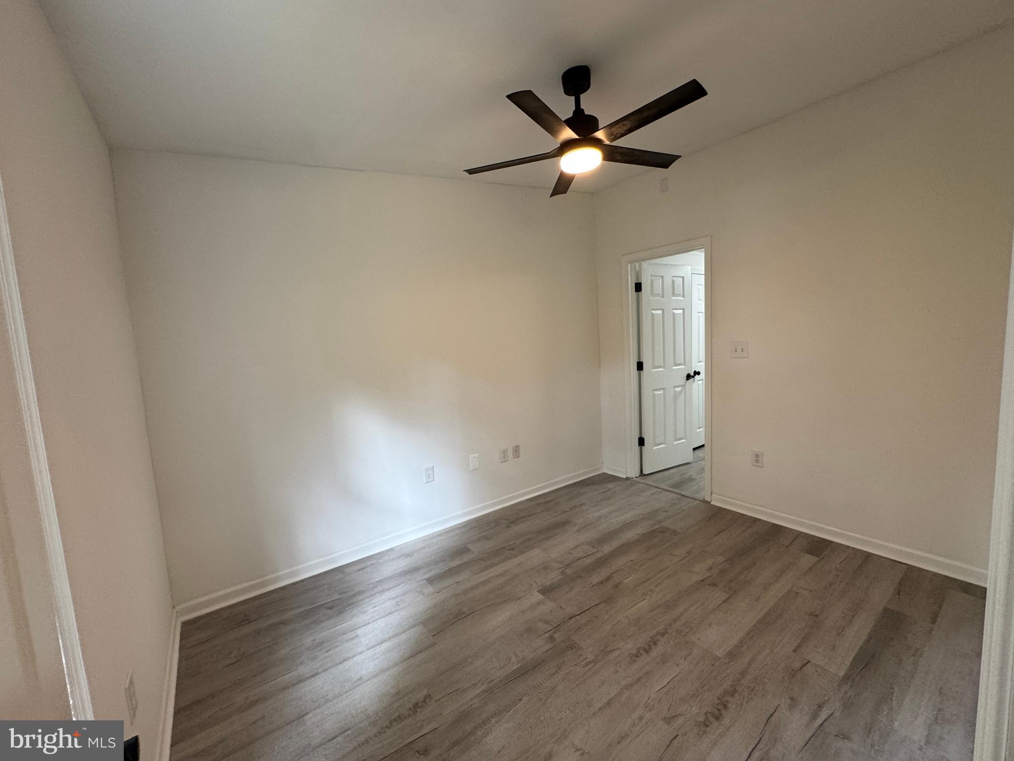26374 Hill Road Ruther Glen, VA 22546 - Photo 12 of 31 an empty room with wooden floor fan and windows