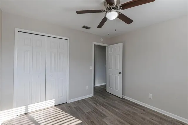 an empty room with closet and a chandelier fan