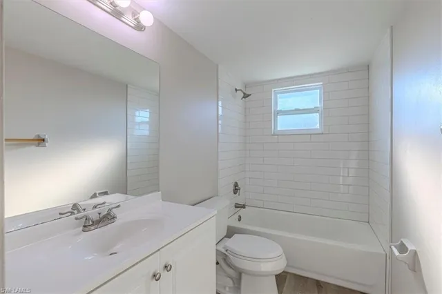 a bathroom with a bathtub shower sink vanity mirror and toilet