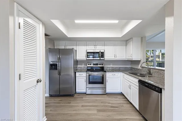 a large kitchen with stainless steel appliances granite countertop a stove and a refrigerator