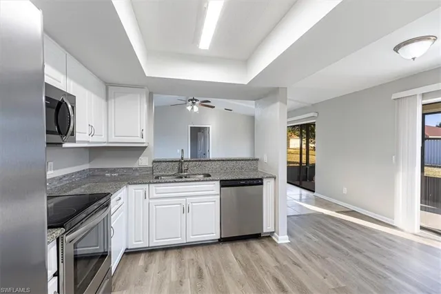 a kitchen with stainless steel appliances granite countertop a sink stove and cabinets