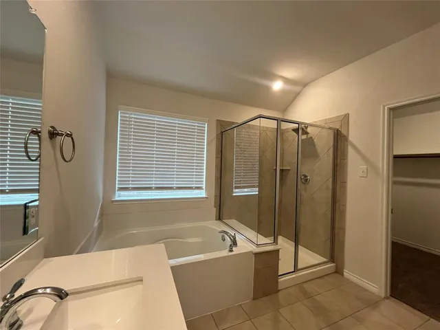 a bathroom with a large tub a sink a mirror and a shower