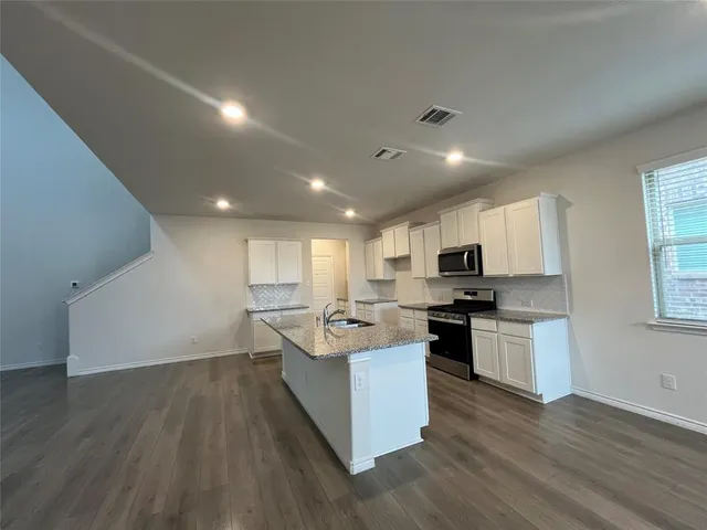 a kitchen with a sink stove and cabinets