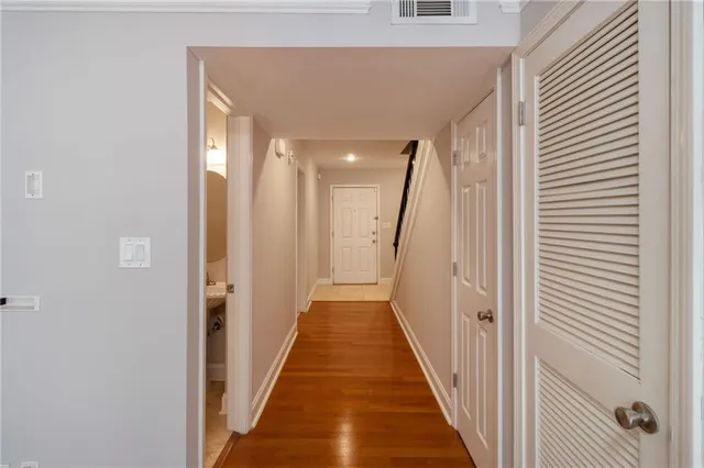 a view of a hallway with wooden floor and staircase