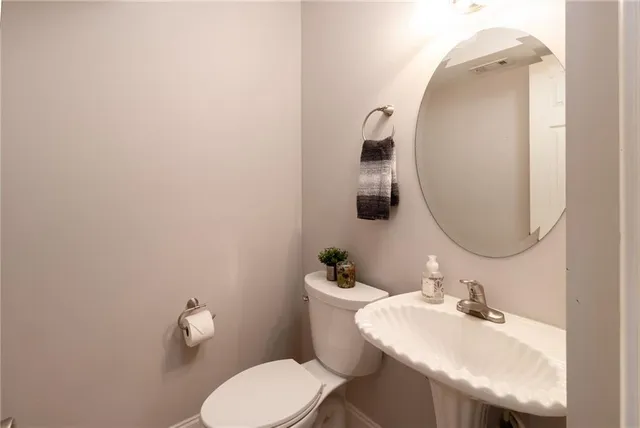 a bathroom with a sink mirror and toilet