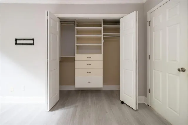 a view of walk in closet with empty racks