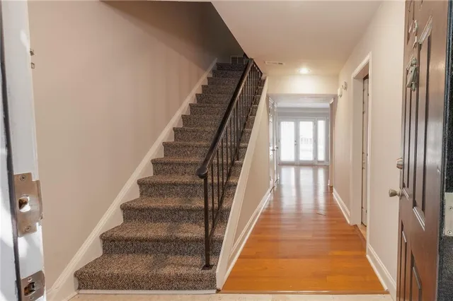 a view of staircase with white walls and a rug