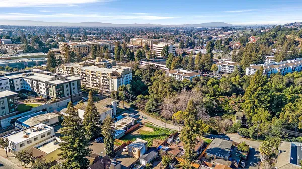 an aerial view of residential houses with city view
