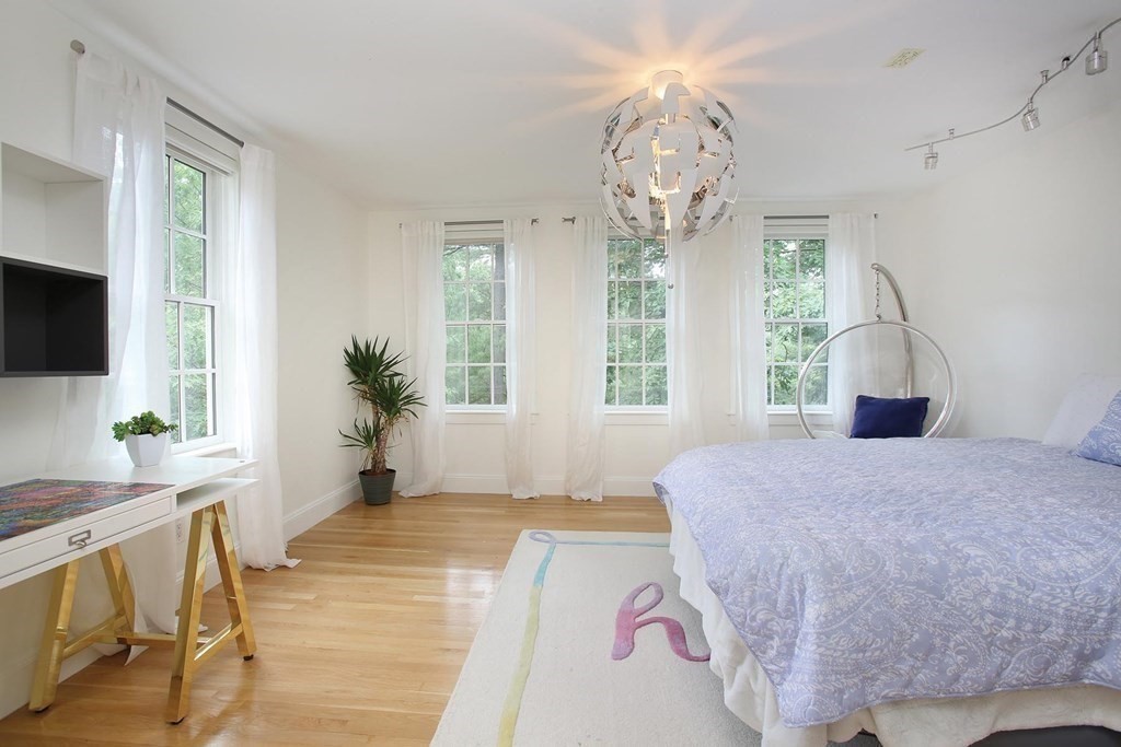 10 Cutter's Bluff Weston, MA 02493 - Photo 22 of 34 a spacious bedroom with a bed and a chandelier