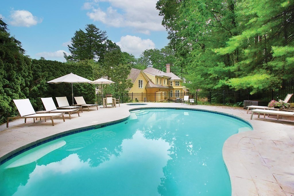 10 Cutter's Bluff Weston, MA 02493 - Photo 30 of 34 a view of a swimming pool with lawn chairs under an umbrella