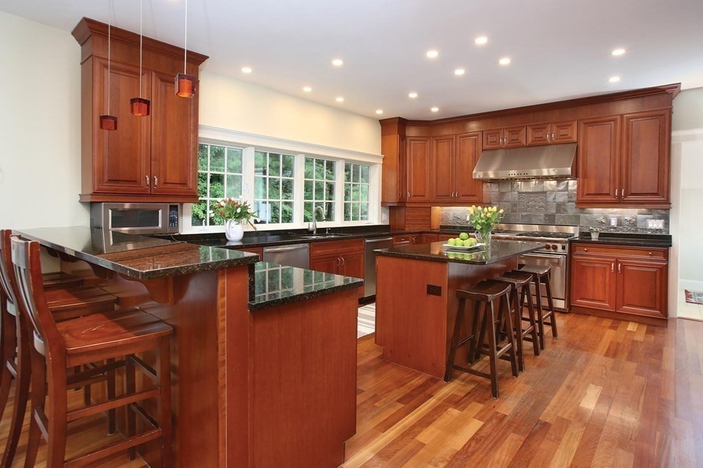 10 Cutter's Bluff Weston, MA 02493 - Photo 10 of 34 a kitchen with stainless steel appliances granite countertop wooden cabinets a sink a stove a dining table and chairs