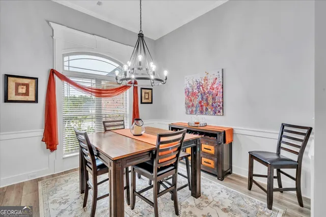 a view of a dining room with furniture wooden floor and chandelier
