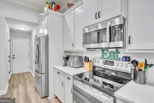 a kitchen with stainless steel appliances granite countertop a refrigerator and stove top oven