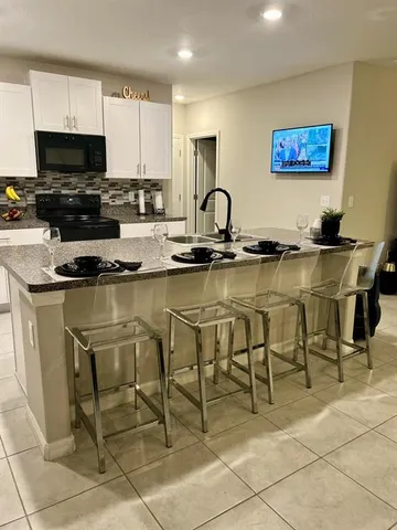 a kitchen with stainless steel appliances granite countertop a stove a sink a dining table and chairs