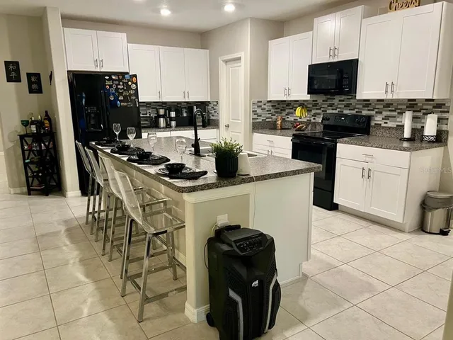 a kitchen with stainless steel appliances a stove a sink a microwave and a refrigerator