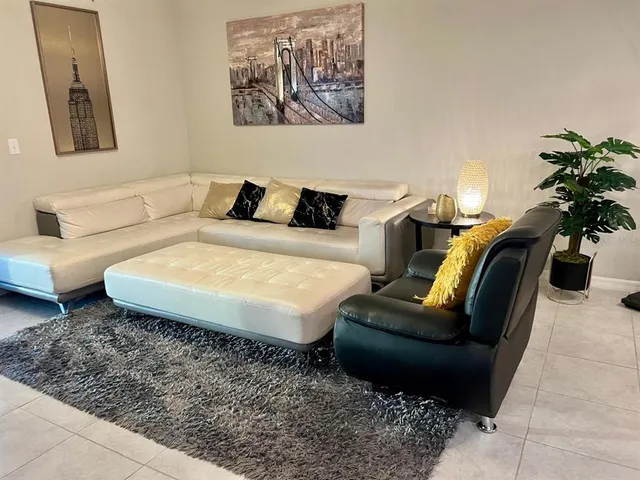 a living room with furniture and painting on the wall