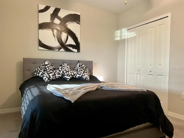 a bedroom with a bed and a painting on the wall