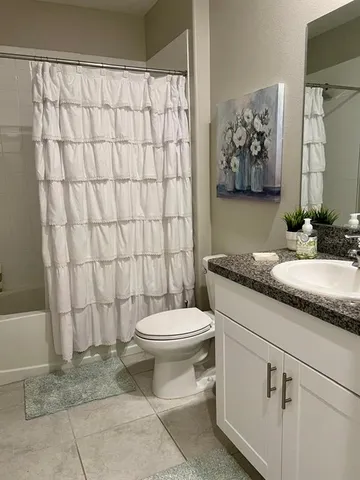 a bathroom with a granite countertop toilet sink and shower