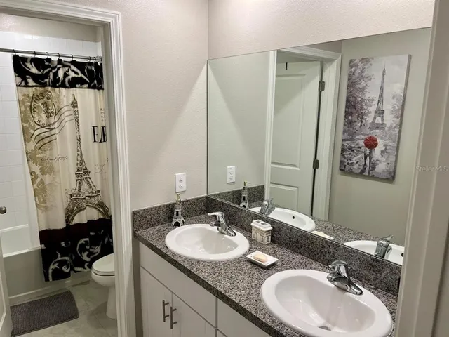 a bathroom with a granite countertop sink and a mirror