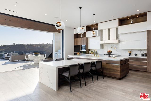 a kitchen with stainless steel appliances granite countertop a sink and white cabinets