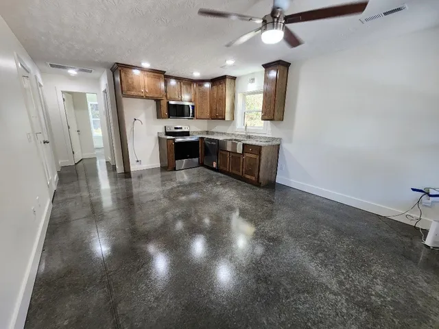 a large kitchen with cabinets and stainless steel appliances