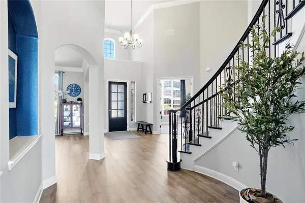 a view of a hallway with wooden floor and staircase