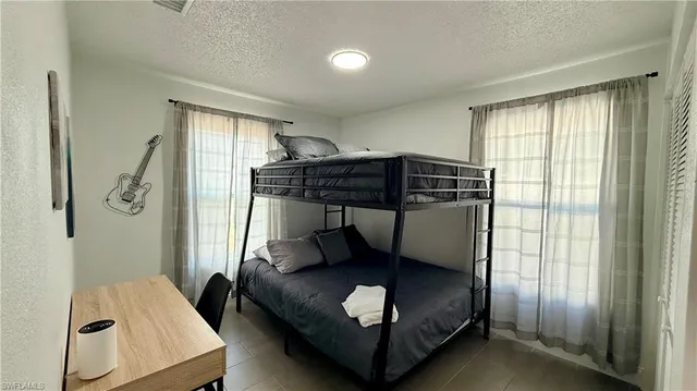 a bedroom with a bunk bed and a window