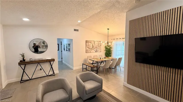 a living room with furniture a rug and a flat screen tv