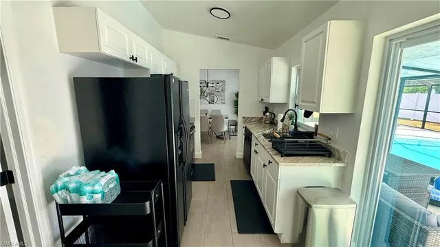 a kitchen with stainless steel appliances a refrigerator a stove a sink and a dining table