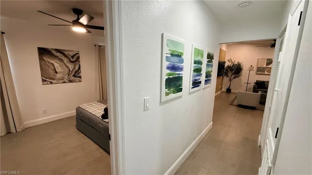 a view of a hallway to a livingroom with furniture and closet