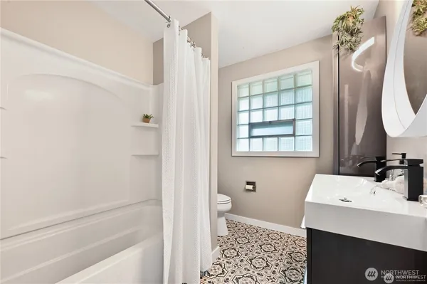 a bathroom with a sink a toilet and shower