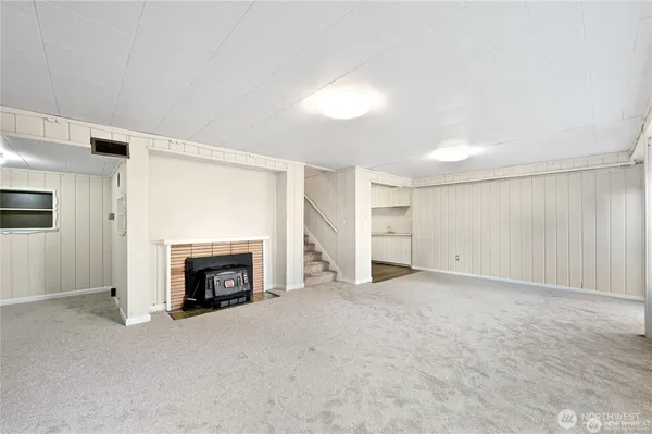 an empty room with a fireplace and window